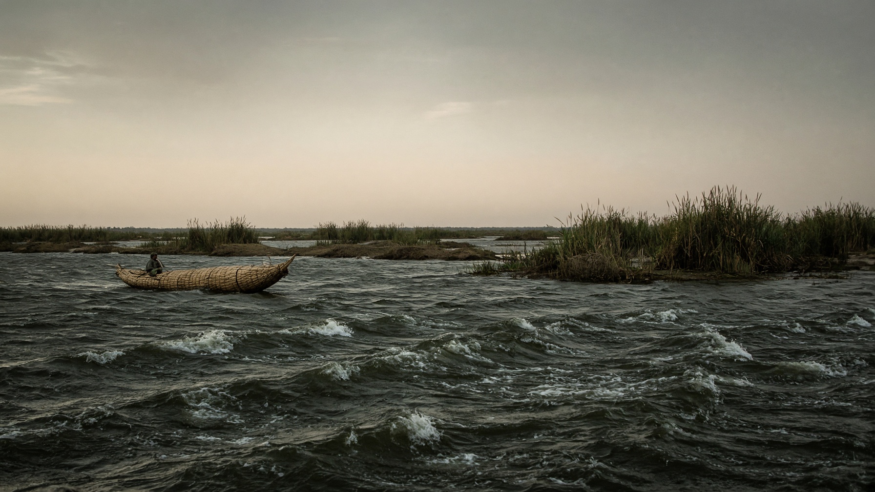 A reed fishing boat on dark freshwater, the surface raked by a sudden south wind.